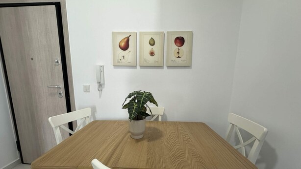 A dining area with a wooden table, white chairs, and a potted plant. - Loutra Suites Aegean Wave Suite (Corinth)