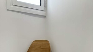 Eine Sitzecke mit Stuhl, Tisch und einer Vase.
