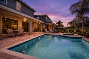 A swimming pool with lounge chairs and a covered patio area. - 6BR family retreat w/ heated pool & hot tub (Kissimmee)