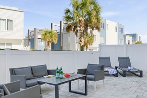 An outdoor seating area with a table, chairs, and a palm tree. - Golf-View Reunion Condo Near Disney | Pool & Gym (Kissimmee)