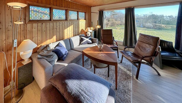 A cozy room with a sofa, chairs, a table, and a view of the outdoors. - Nice home in Karrebæksminde with WiFi (Karrebæksminde)
