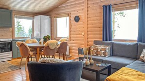 L’intérieur d’une cabane en bois comprend un coin repas, une cuisine et un salon.