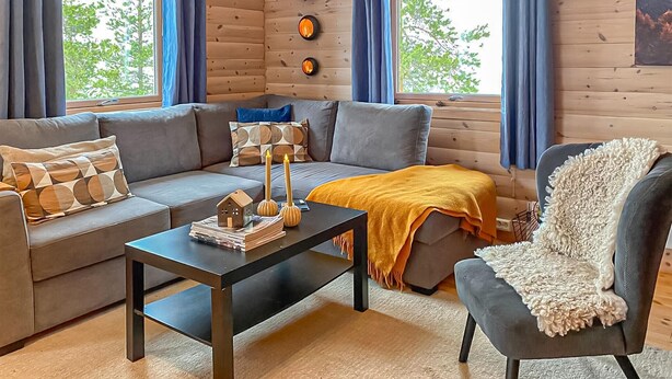 Un salon chaleureux avec un canapé, une table basse, un fauteuil et une cheminée.