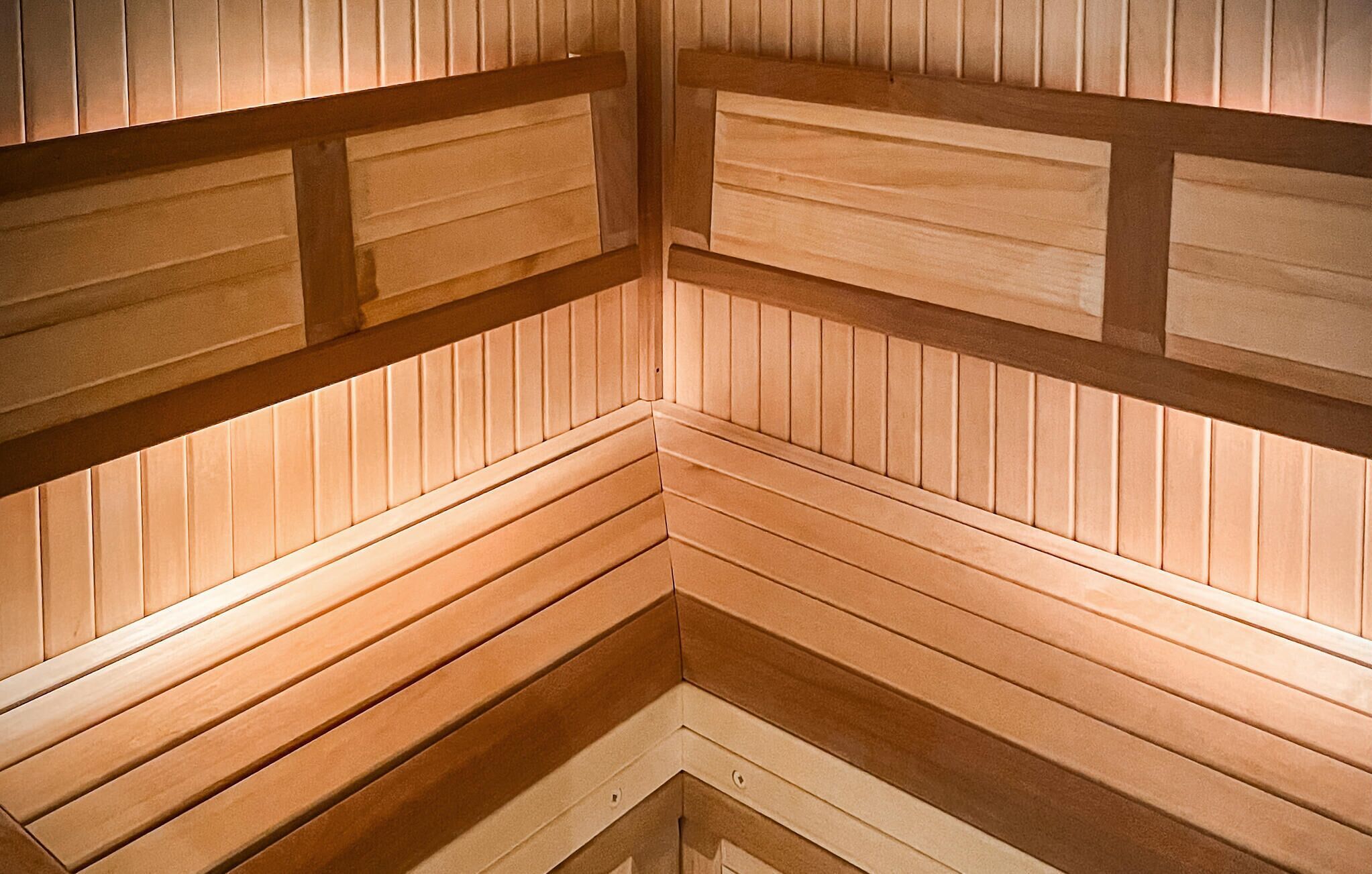 Un sauna avec des panneaux et des bancs en bois.