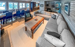A spacious living area with a sofa, coffee table, and dining set.