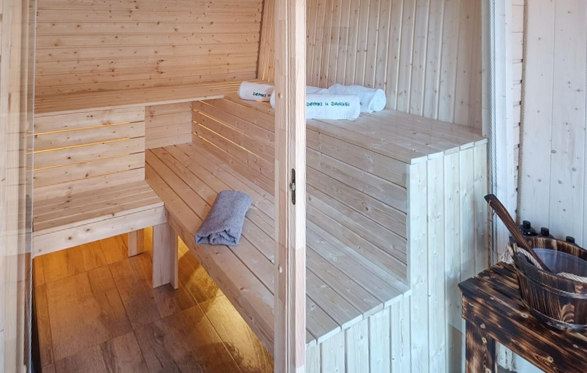 A wooden sauna room with benches and towels.