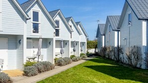A row of modern, light-colored houses with a well-maintained lawn and outdoor seating. - 2 bedroom lovely home in Gaski (Gaski)