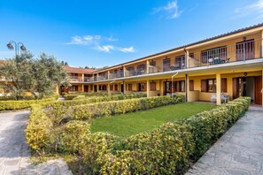 A hotel with a courtyard, multiple balconies, and a well-maintained garden. - Residence La Perla - Apt 40, Monte Isola, Italy (Monte Isola)