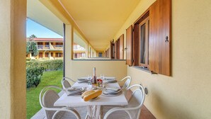 A dining area with a table set for two, a bottle, and bread. - Residence La Perla - Apt 09, Monte Isola, Italy (Monte Isola)