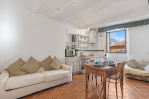 A compact living space with a sofa, dining table, and kitchenette. - House Old Town 50m Beach and Shop, Menton, France (Menton)