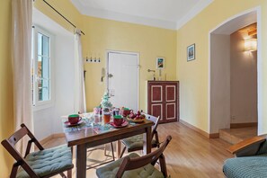 Un comedor con mesa de madera, sillas y una preparación para el desayuno.
