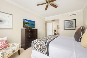 A bedroom with a bed, a dresser, a ceiling fan, and a painting on the wall. - Honua Kai | Ocean View 11 BR, Sleeps 28 | Car Incl. w/ 6+ Nights | HKK ML-3380 by KBM (Lahaina)