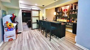 Eine moderne Küche mit Bar, Holzboden und gemütlicher Sitzecke.