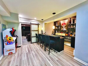 Eine moderne Küche mit Bar, Holzboden und gemütlicher Sitzecke.