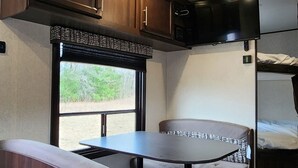 L’intérieur d’un véhicule récréatif comprend un coin cuisine, un espace repas et un coin nuit.