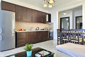 Eine moderne Küche mit dunklen Holzschränken, einem Edelstahlkühlschrank und einem Essbereich mit Tisch und Stühlen.