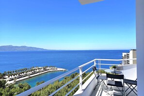 A balcony with a view of the sea, a small table with a plant, and a chair. - Two Bedroom Apartment With Sea View-061, Sarandë, Albania (Sarandë)