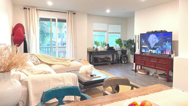 Un salon comprenant un canapé, une table basse, un téléviseur et un coin repas avec une table et des chaises.