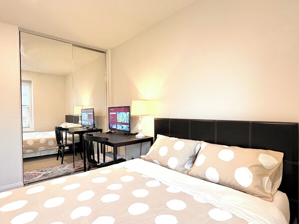 A bedroom with a bed, two monitors, a desk, and a chair. - Polka Dot Cozy Retreat，Quiet, Clean & Comfortable Stay (Chino Hills)