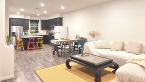 Un salon moderne comprenant un canapé, une table basse et un coin repas avec des chaises et une table.