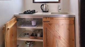 A compact kitchen with a sink, stove, and wooden cabinets.
