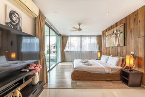 A modern bedroom with a large bed, a TV, and a ceiling fan. - Seaview Rooftop Pool Villa Near Beach V210 (Rawai)