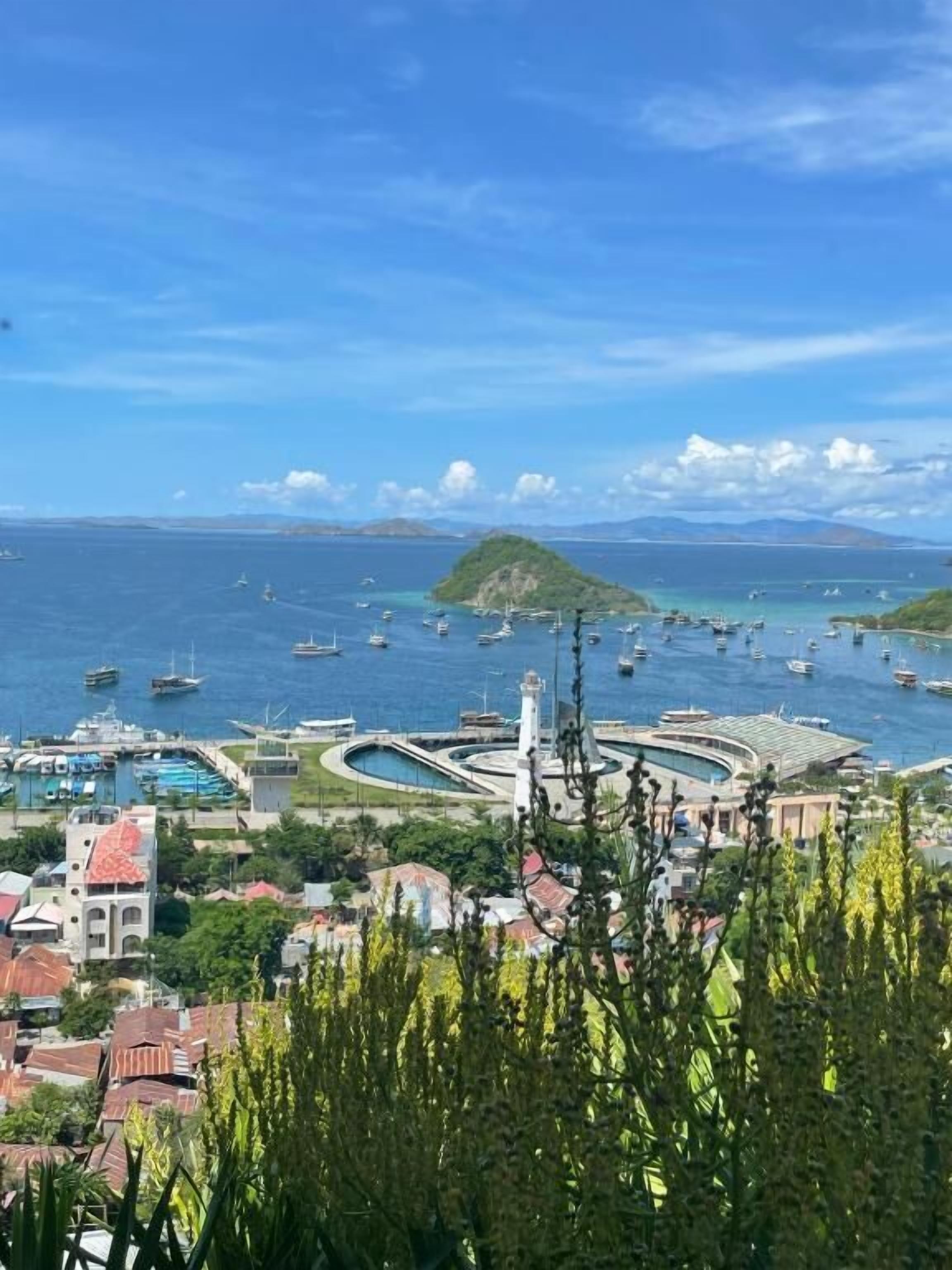 A coastal town with a marina, buildings, and a lighthouse.