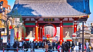 A traditional Chinese gate with intricate roof design and red pillars, surrounded by a crowd of people. - HUBEX AKIHABARA (Tokyo)
