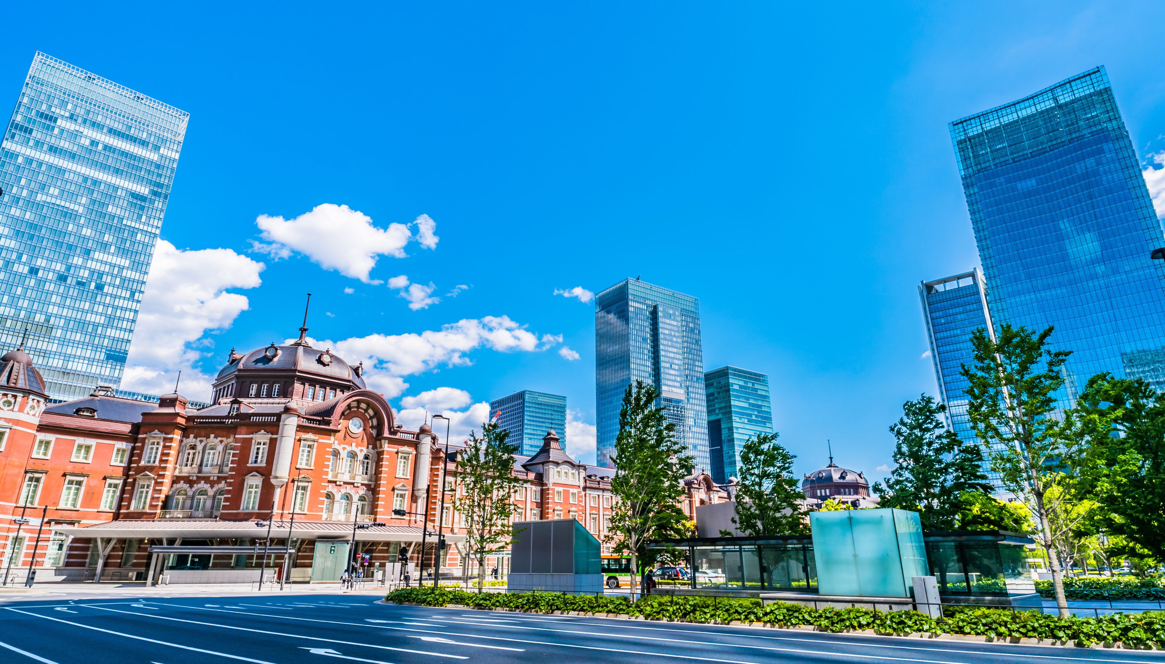 Un paisaje urbano con modernos rascacielos, un edificio histórico con cúpula y un cielo azul despejado.