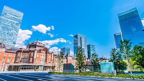 A cityscape with modern skyscrapers, a historic building with a dome, and a clear blue sky. - HUBEX AKIHABARA (Tokyo)