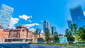 A cityscape with modern skyscrapers, a historic building with a dome, and a clear blue sky. - HUBEX AKIHABARA (Tokyo)