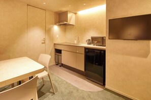 Cocina compacta con comedor, que incluye una mesa, sillas y un microondas.