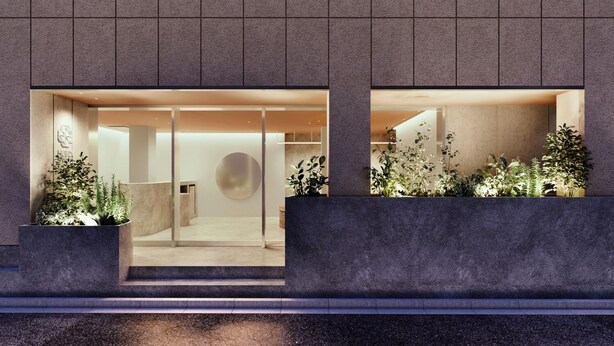 Fachada moderna de un edificio con amplios ventanales, un elemento decorativo circular y plantas en macetas.