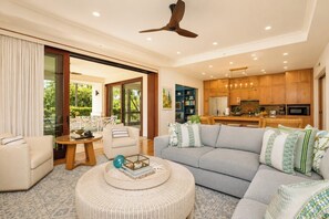 Ein modernes Wohnzimmer mit einer Couch, einem Couchtisch und einem Essbereich mit Tisch und Stühlen.