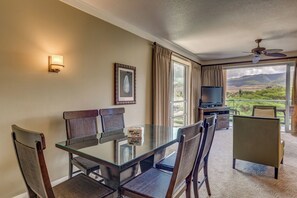 A hotel room with a dining table, chairs, a television, and a balcony with a view. - 2 Honua Kai Villas | Mountain View | Sleeps 10 | Free Car w/ 6+ Nights | ML-3827 (Lahaina)