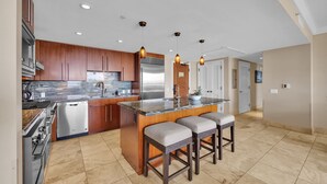 Una cocina moderna con una isla central, electrodomésticos de acero inoxidable y armarios de madera.
