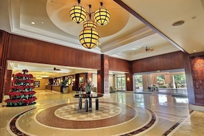 Eine Hotelhalle mit einer Rezeption, einem Weihnachtsbaum und einer runden Sitzecke.