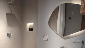 Een moderne badkamer met douche, toilet en wastafel.
