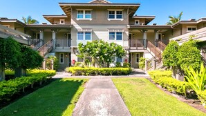 A multi-story residential building with a central courtyard, balconies, and a well-maintained lawn. - Halii Kai | Ocean View 7 BR, Sleeps 20 | Car Incl. w/ 6+ Nights | HLI ML-3872 by KBM (Waikoloa)
