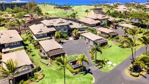 Een resort met meerdere gebouwen, een golfbaan en uitzicht op de oceaan.