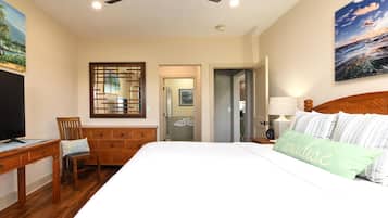 A bedroom with a bed, a desk, a chair, a ceiling fan, and a painting on the wall.