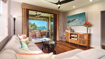 A living room with a sofa, a coffee table, a wooden cabinet, and a painting on the wall.