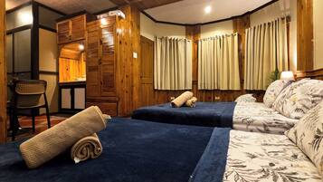 A room with two beds, a chair, and a wooden wardrobe.