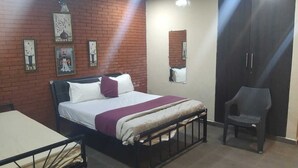 Een kamer met een bed, een stoel en een kast.