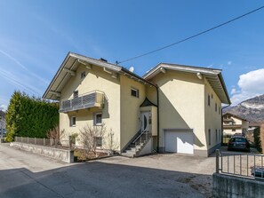 A two-story residential building with a balcony, a garage, and a staircase leading to the entrance. - Spacious vacation home where your dog is welcome (Radfeld)