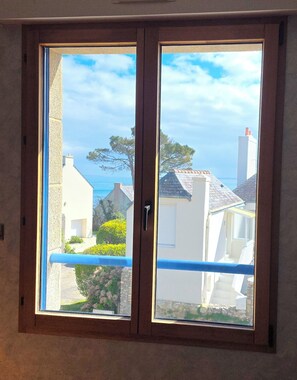 A window with a view of neighboring houses and a clear sky. - Bretagne large seaside house (Moëlan-sur-Mer)