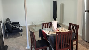 A dining area with a table, chairs, a punching bag, a sofa, and a refrigerator. - Saffire Villa  (Tacoma)