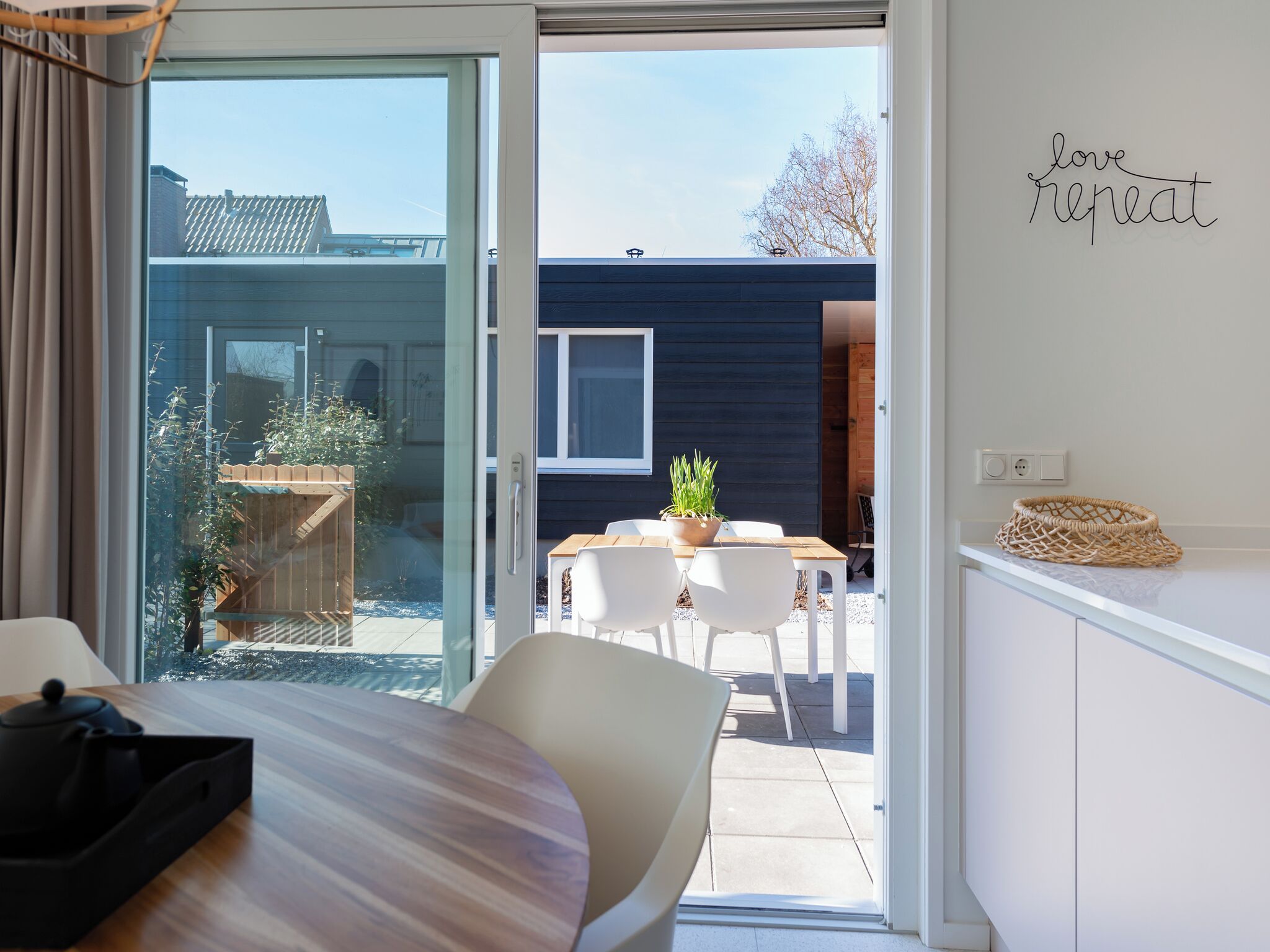 Un intérieur moderne avec une porte-fenêtre coulissante donnant sur un patio extérieur.