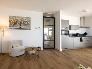 Un appartement moderne comprenant un salon, un coin repas et une cuisine.