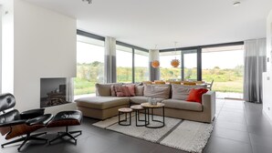 Una sala moderna con un sofá modular, una mesa de centro y una chimenea.